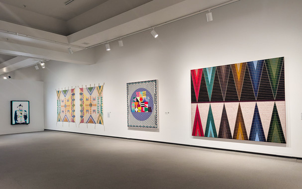 A large room with large and colorful artworks on its wall.