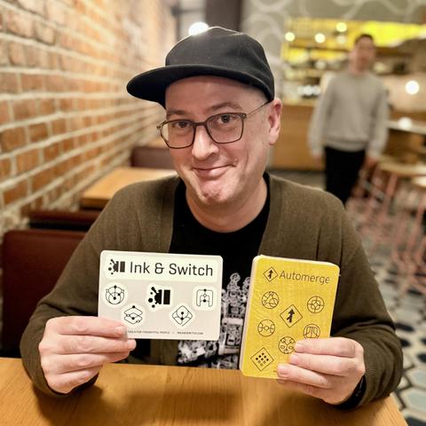 Todd seaofclouds.com holds up Ink & Switch and Automerge sticker sheets 