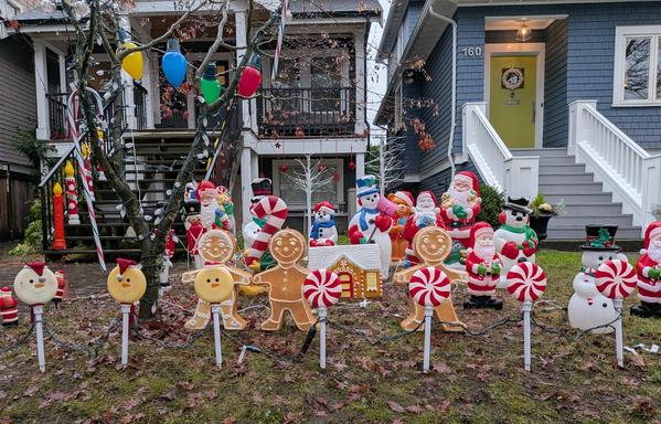 A front lawn is full of rigidly lined up Christmas statues and decorations